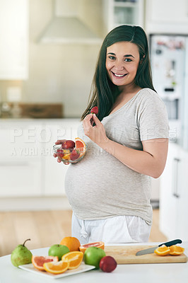 Buy stock photo Shot of a pregnant woman making a fruit salad in her kitchen