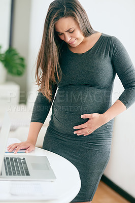 Buy stock photo Shot of a young pregnant woman feeling unwell while working from home