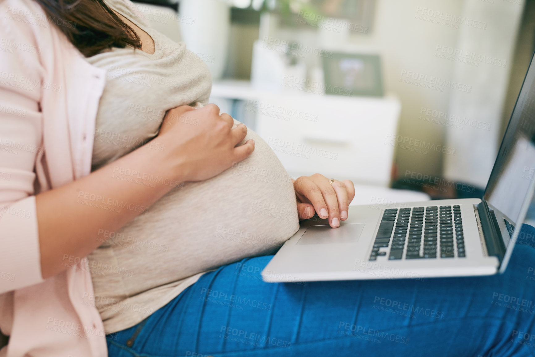 Buy stock photo Shot of an unrecognizable young pregnant woman working from home