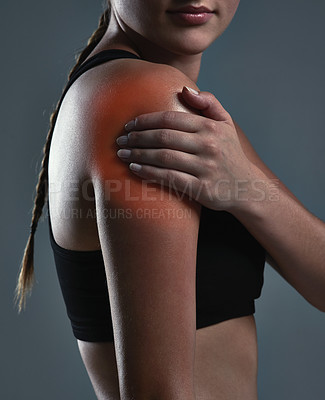 Buy stock photo Cropped shot of a sporty young woman suffering from a shoulder injury