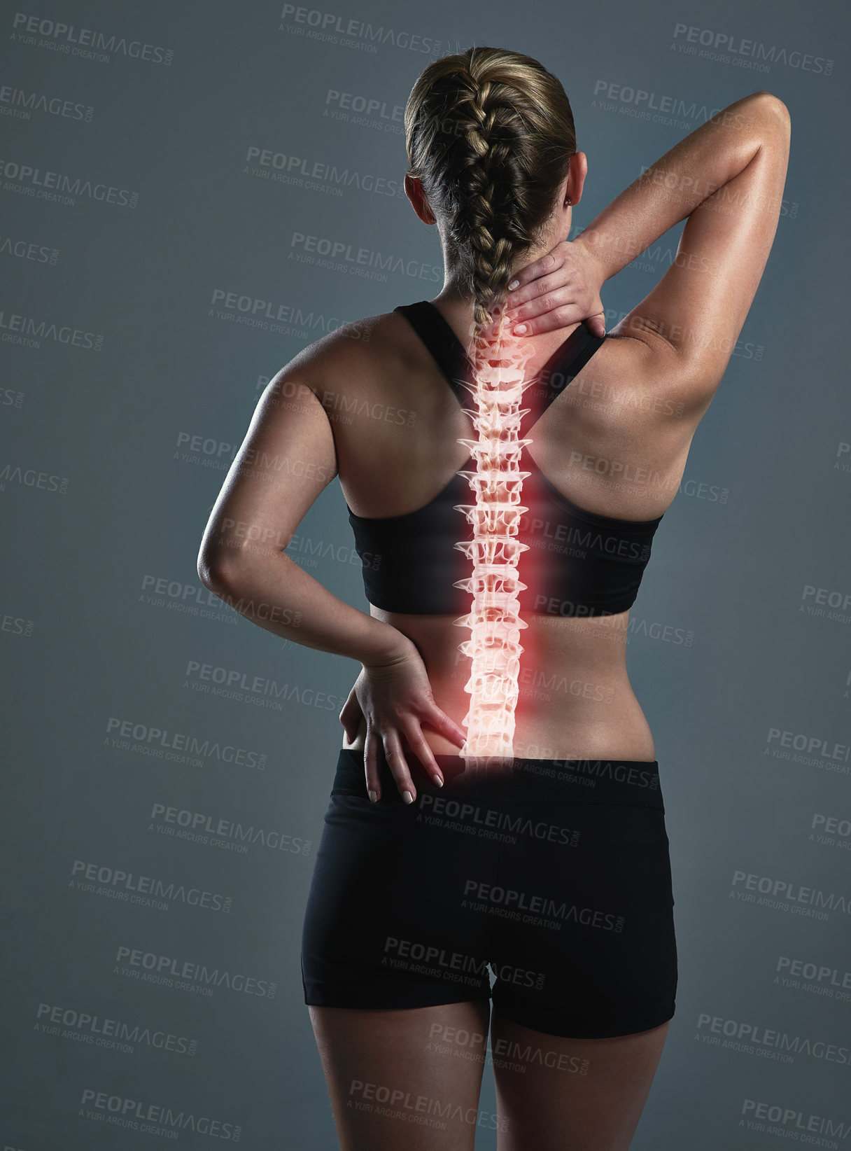 Buy stock photo Rearview shot of a sporty young woman holding her back in pain