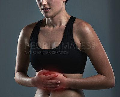 Buy stock photo Studio shot of a sporty young woman experiencing stomachaches