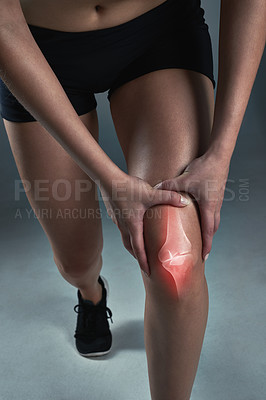 Buy stock photo Studio shot of a sporty young woman suffering from a knee injury