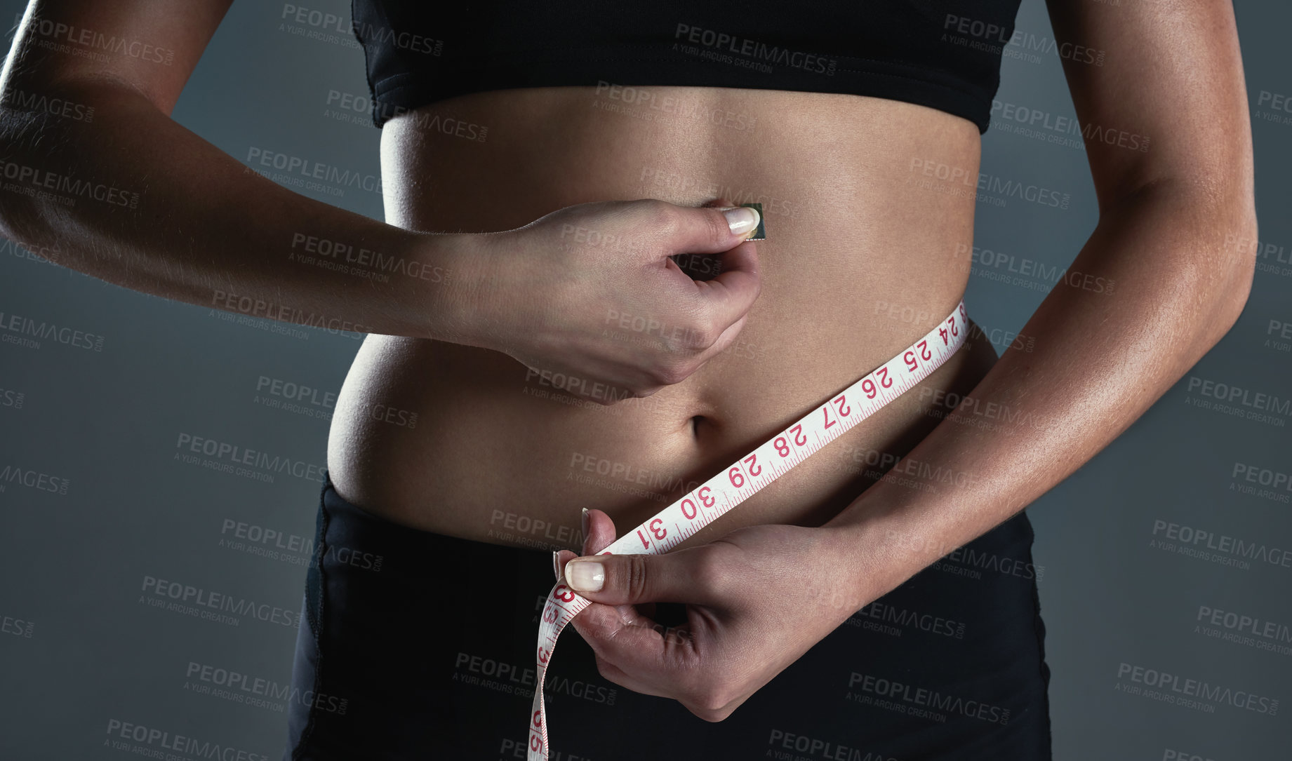 Buy stock photo Cropped shot of a sporty young woman measuring her waist