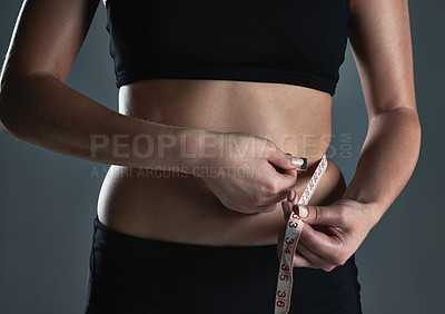 Buy stock photo Cropped shot of a sporty young woman measuring her waist