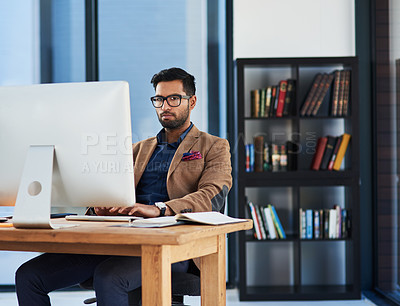 Buy stock photo Cropped shot of a young businessman working on a computer in an office