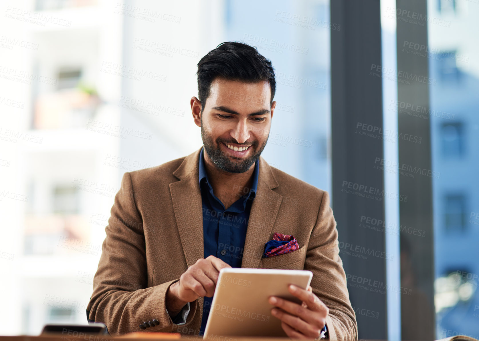 Buy stock photo Cropped shot of a young businessman working on a digital tablet in an office