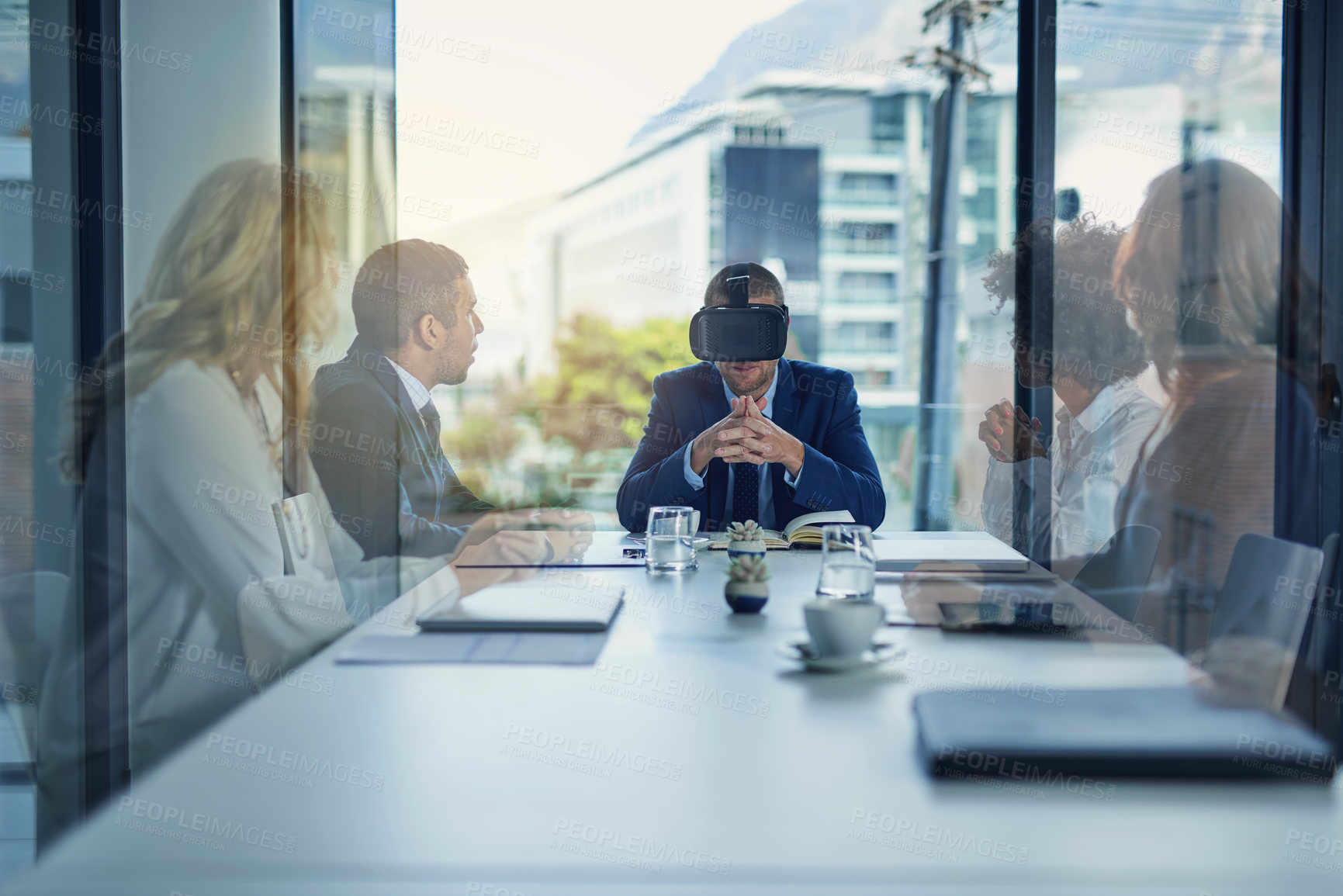 Buy stock photo Shot of a businessman wearing a VR headset during a meeting in the boardroom