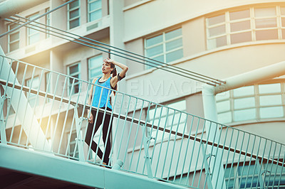 Buy stock photo Shot of a young woman looking exhausted during her morning run