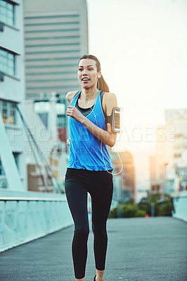 Buy stock photo Shot of a young woman out in the city for her morning run