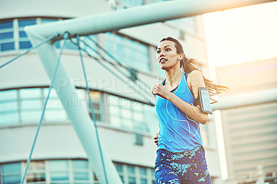 Buy stock photo Shot of a young woman out in the city for her morning run