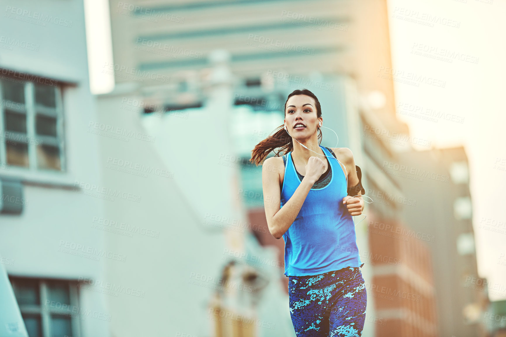 Buy stock photo Shot of a young woman out in the city for her morning run