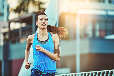 Buy stock photo Woman, fitness and running in street, morning and training for exercise, health and speed in city. Girl, person and runner with earphones, phone and audio streaming subscription in road for workout