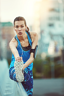 Buy stock photo Shot of sporty young woman stretching before her run