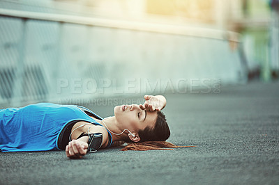 Buy stock photo Shot of a young woman looking exhausted during her morning run