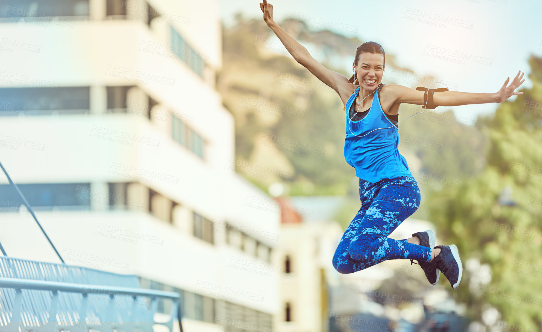 Buy stock photo Shot of a young woman jumping in mid air after her workout