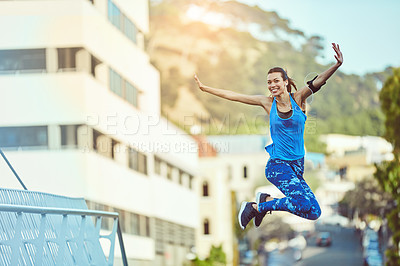 Buy stock photo Shot of a young woman jumping in mid air after her workout