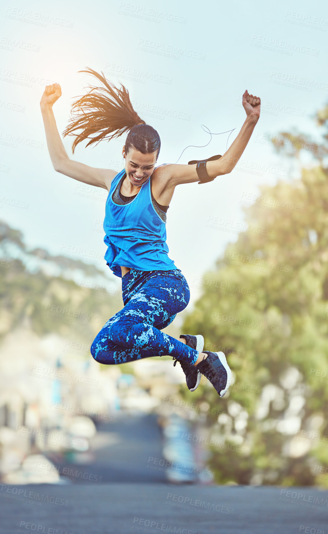 Buy stock photo Shot of a young woman jumping in mid air after her workout