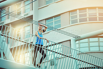 Buy stock photo Shot of a young woman looking exhausted during her morning run