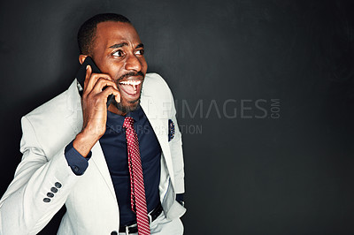 Buy stock photo Cropped shot of a young businessman looking stressed out while talking on a cellphone against a dark background
