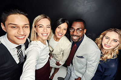 Buy stock photo Portrait of a group of businesspeople taking a selfie against a dark background