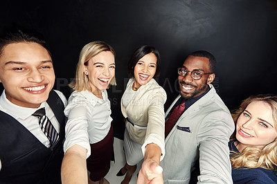 Buy stock photo Portrait of a group of businesspeople taking a selfie against a dark background