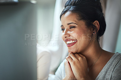 Buy stock photo Shot of a happy young businesswoman looking at her computer screen while sitting in the office