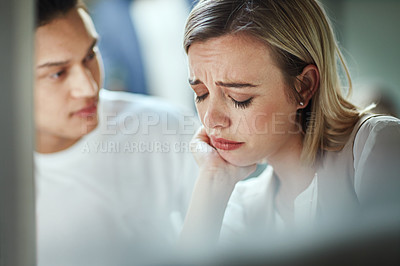 Buy stock photo Shot of a young businessman consoling an upset colleague as they sit together in the office