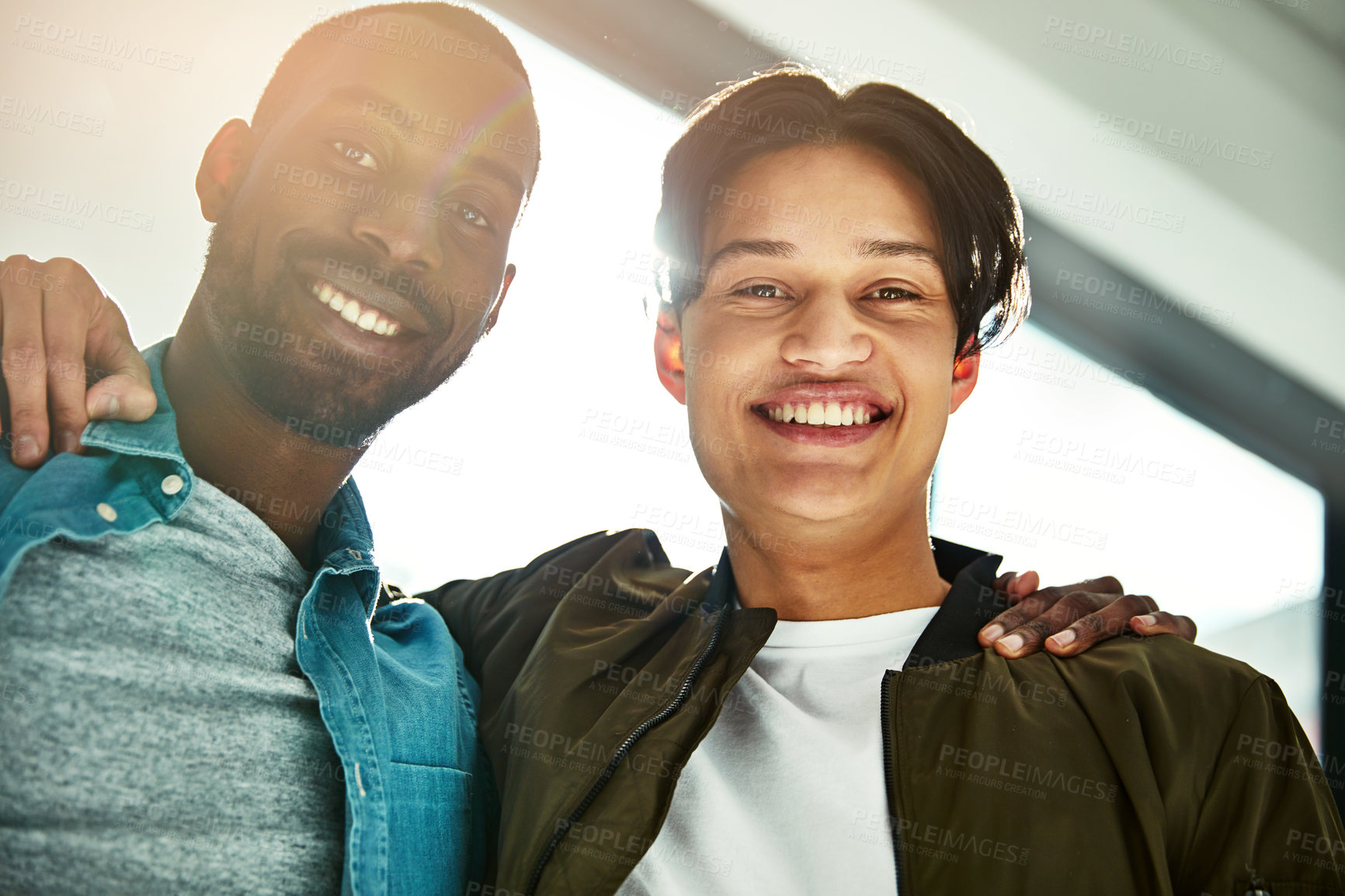 Buy stock photo Portrait of two happy colleagues posing with their arms around each other in the office