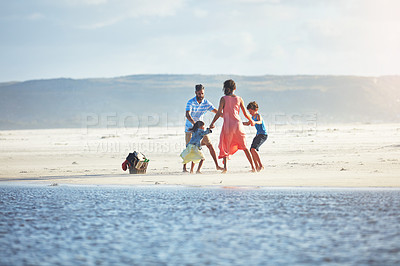 Buy stock photo Shot of a family of four enjoying a day at the beach