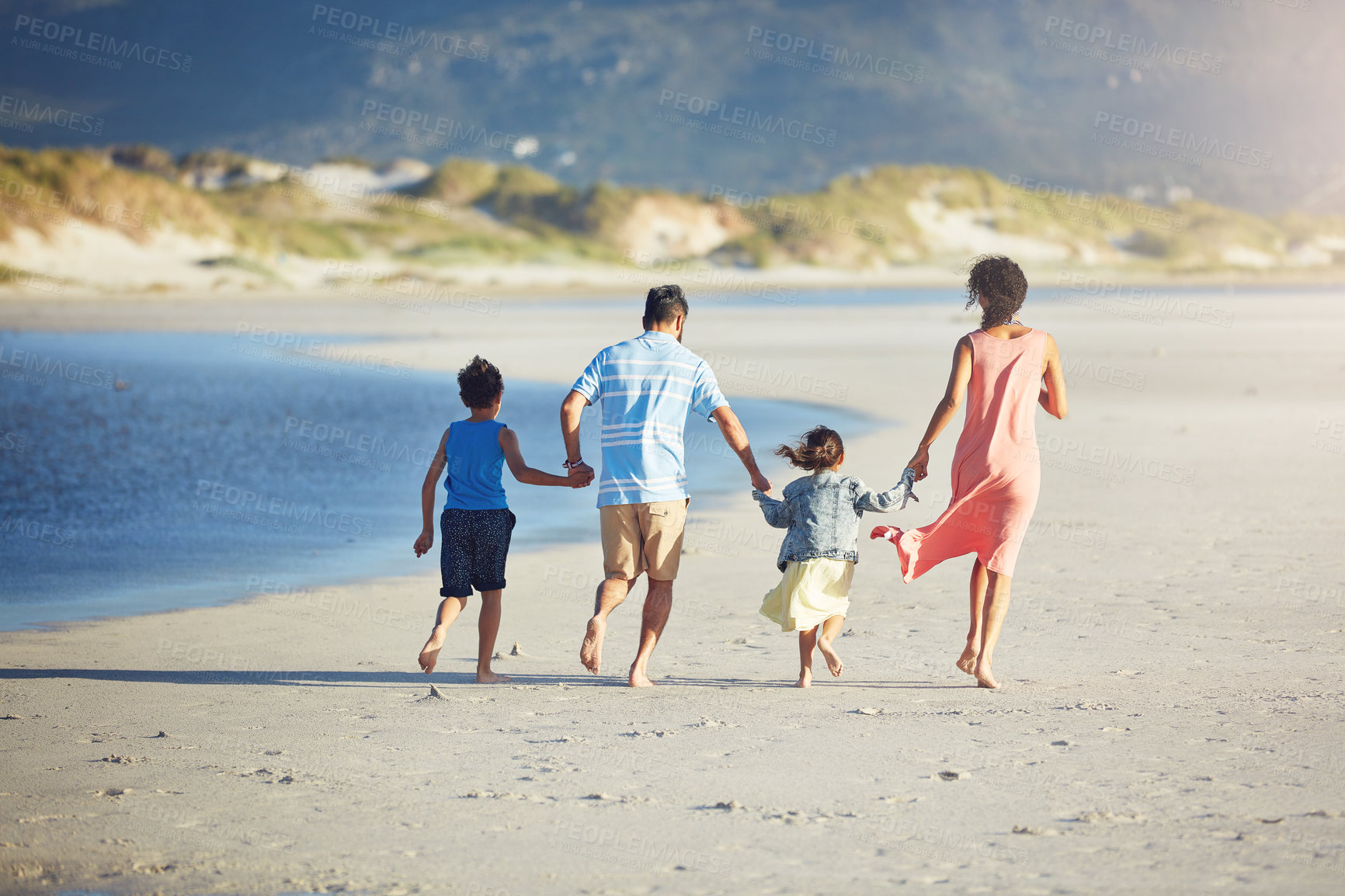 Buy stock photo Shot of a family of four enjoying a day at the beach