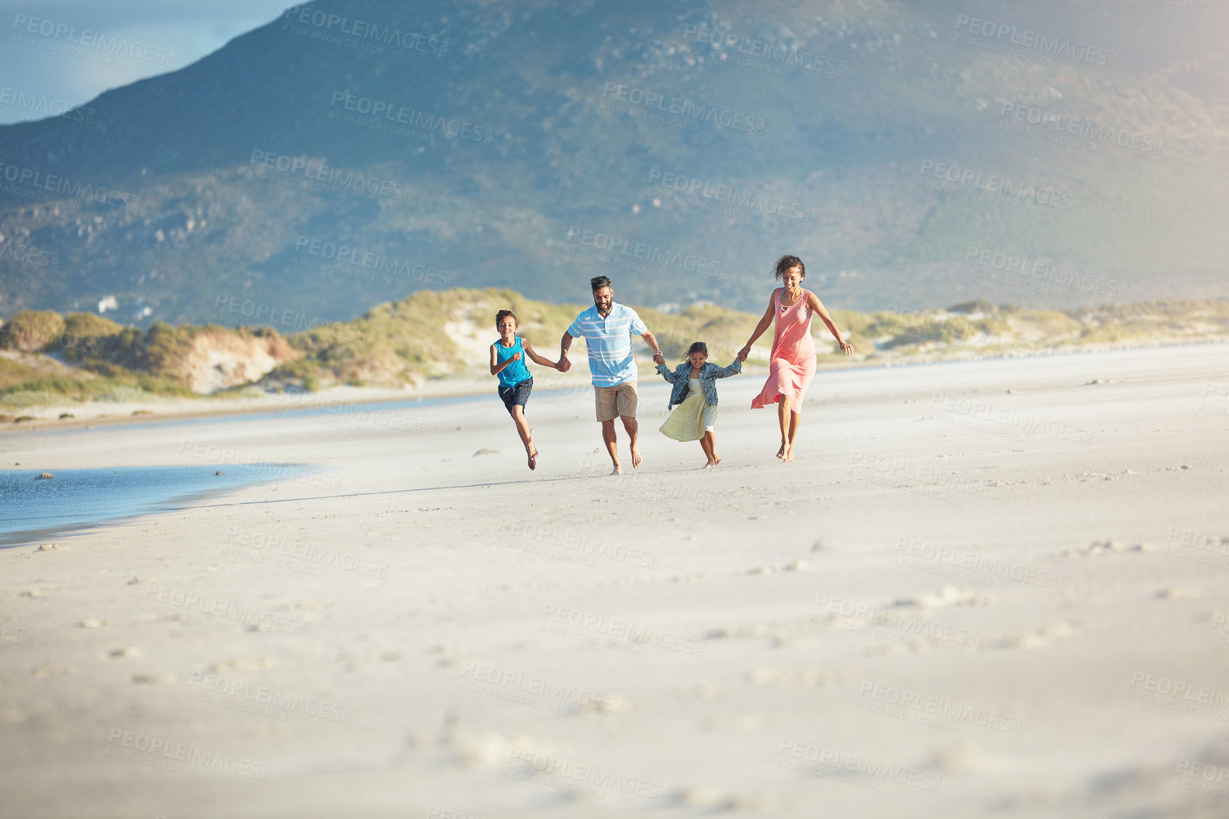 Buy stock photo Shot of a family of four enjoying a day at the beach