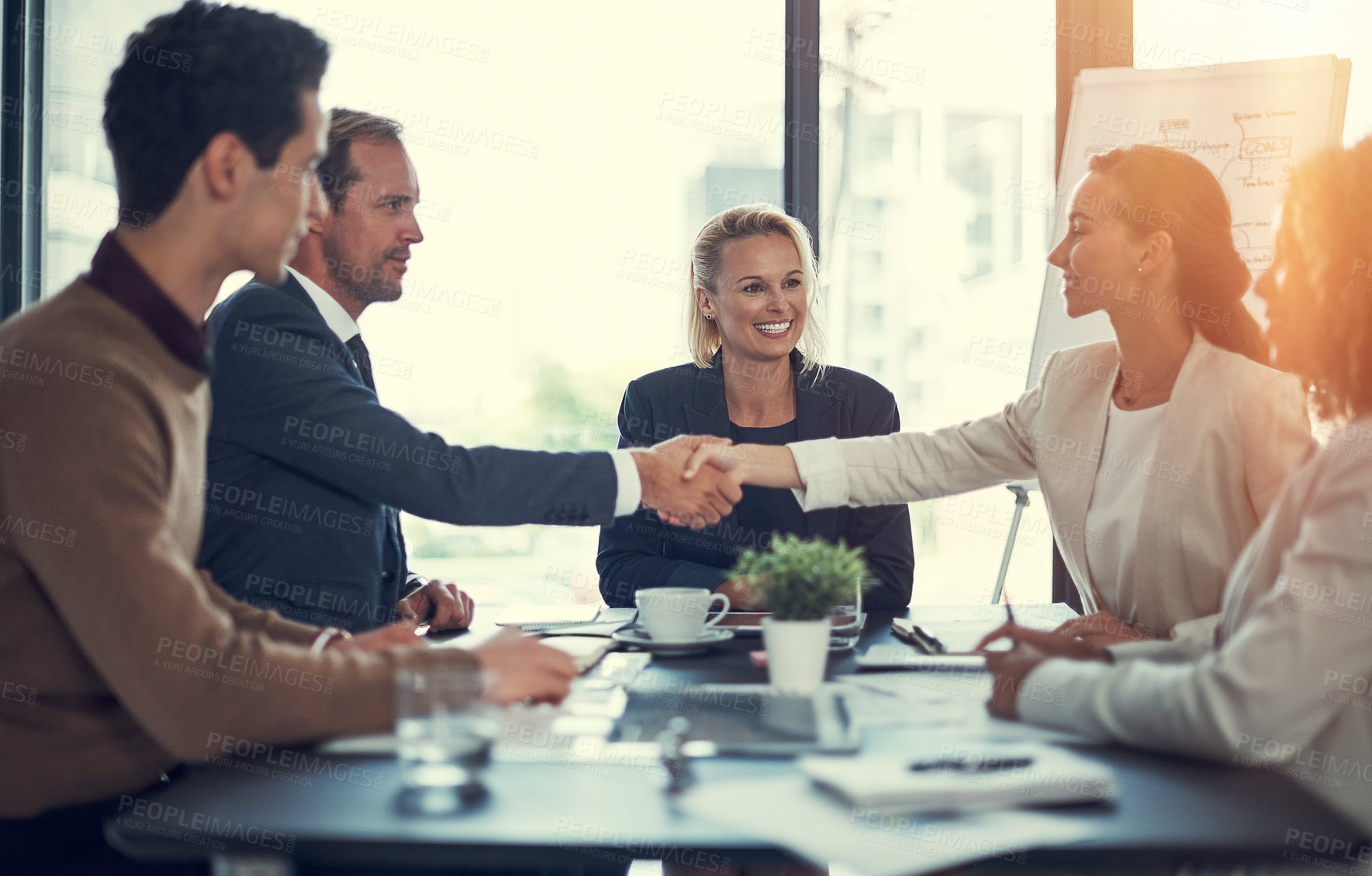 Buy stock photo Cropped shot of businesspeople shaking hands during a meeting in an office