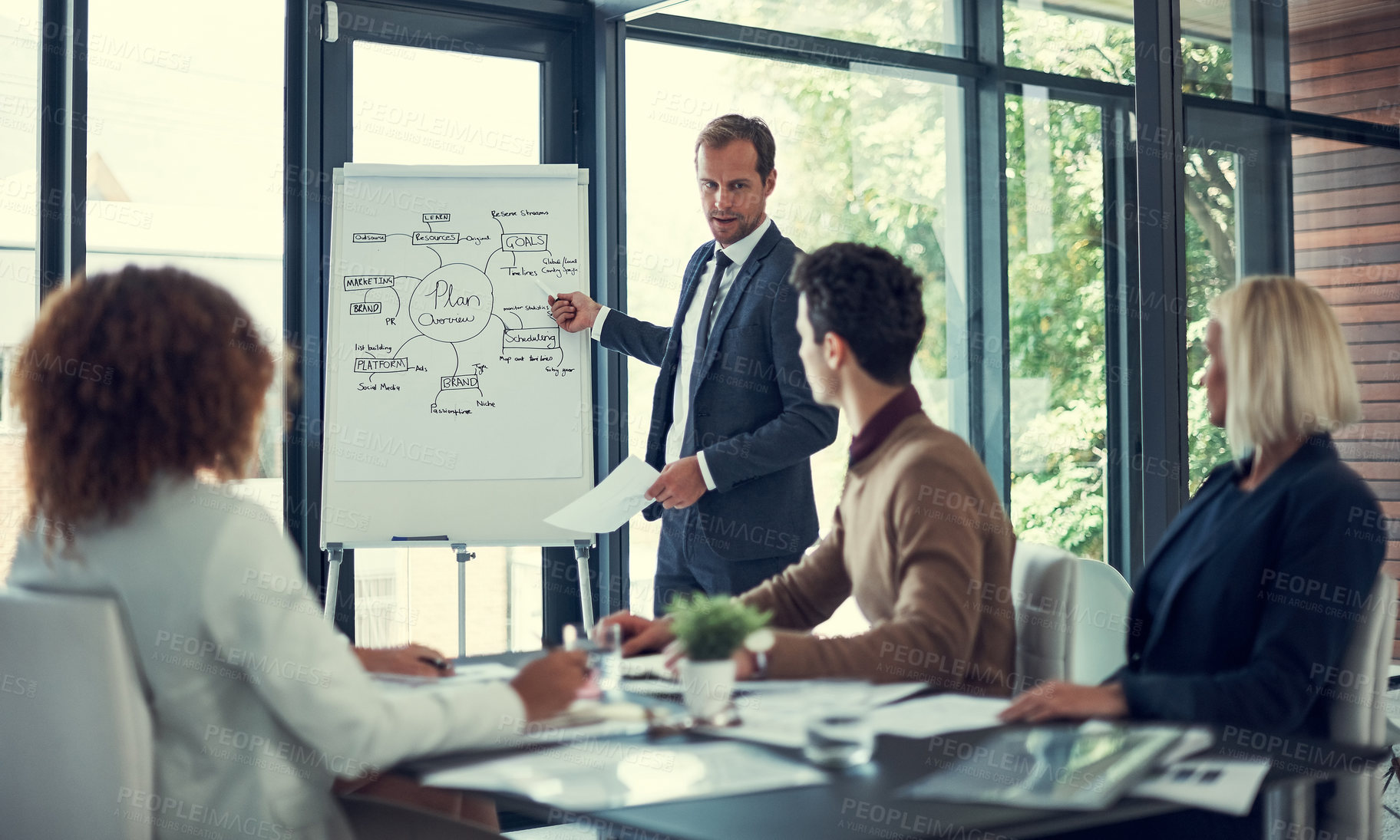 Buy stock photo Cropped shot of a businessman giving a presentation to his colleagues in the boardroom