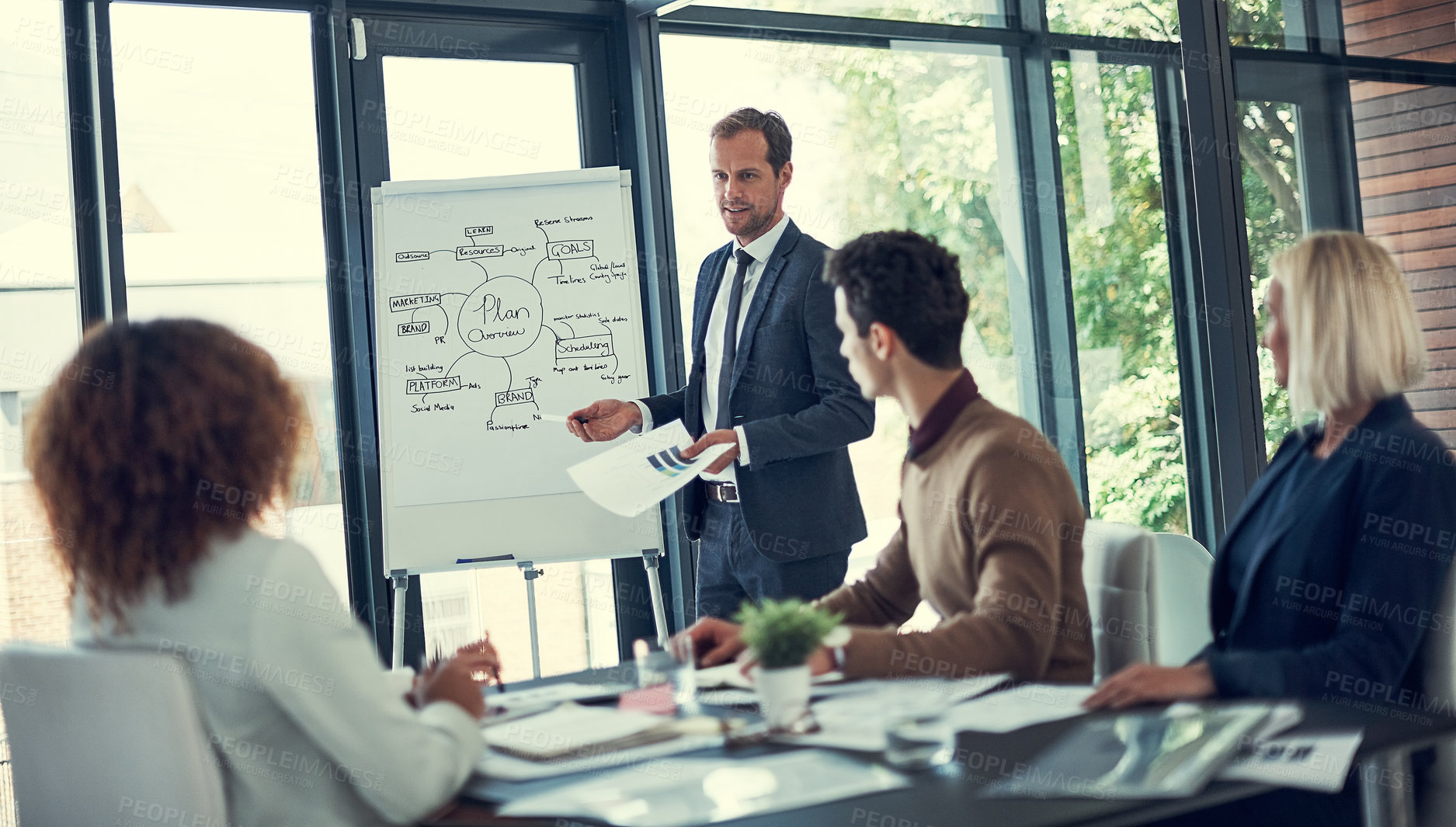 Buy stock photo Cropped shot of a businessman giving a presentation to his colleagues in the boardroom