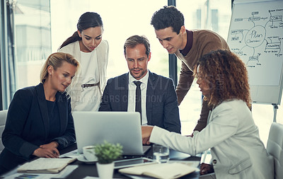 Buy stock photo Cropped shot of businesspeople working together on a laptop in an office