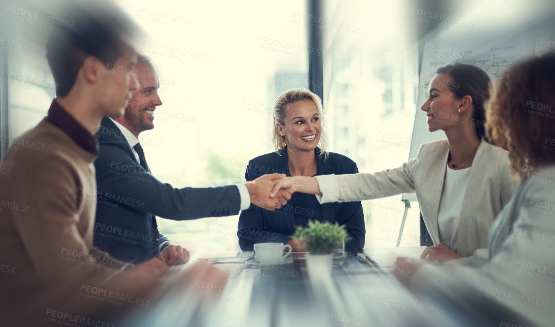 Buy stock photo Cropped shot of businesspeople shaking hands during a meeting in an office