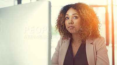 Buy stock photo Shot of a thoughtful young businesswoman working at her desk in a modern office