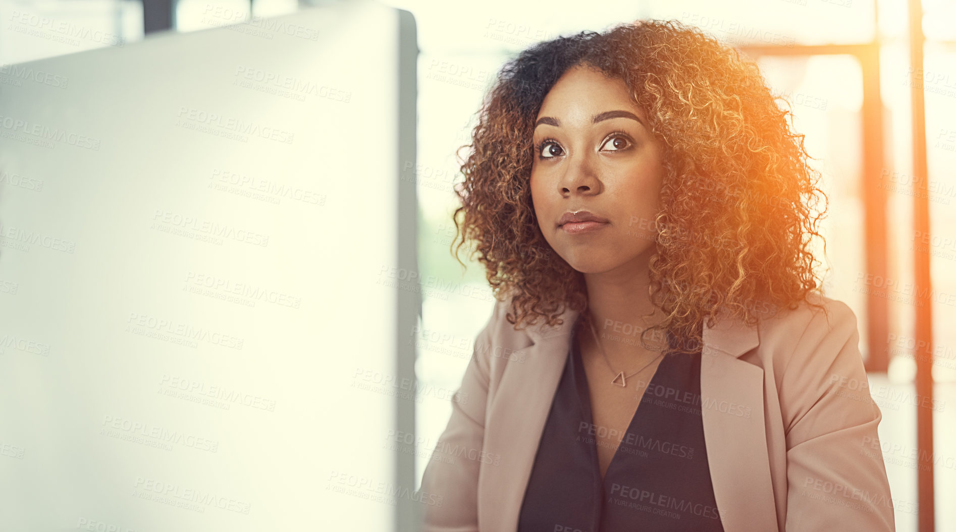 Buy stock photo Shot of a thoughtful young businesswoman working at her desk in a modern office