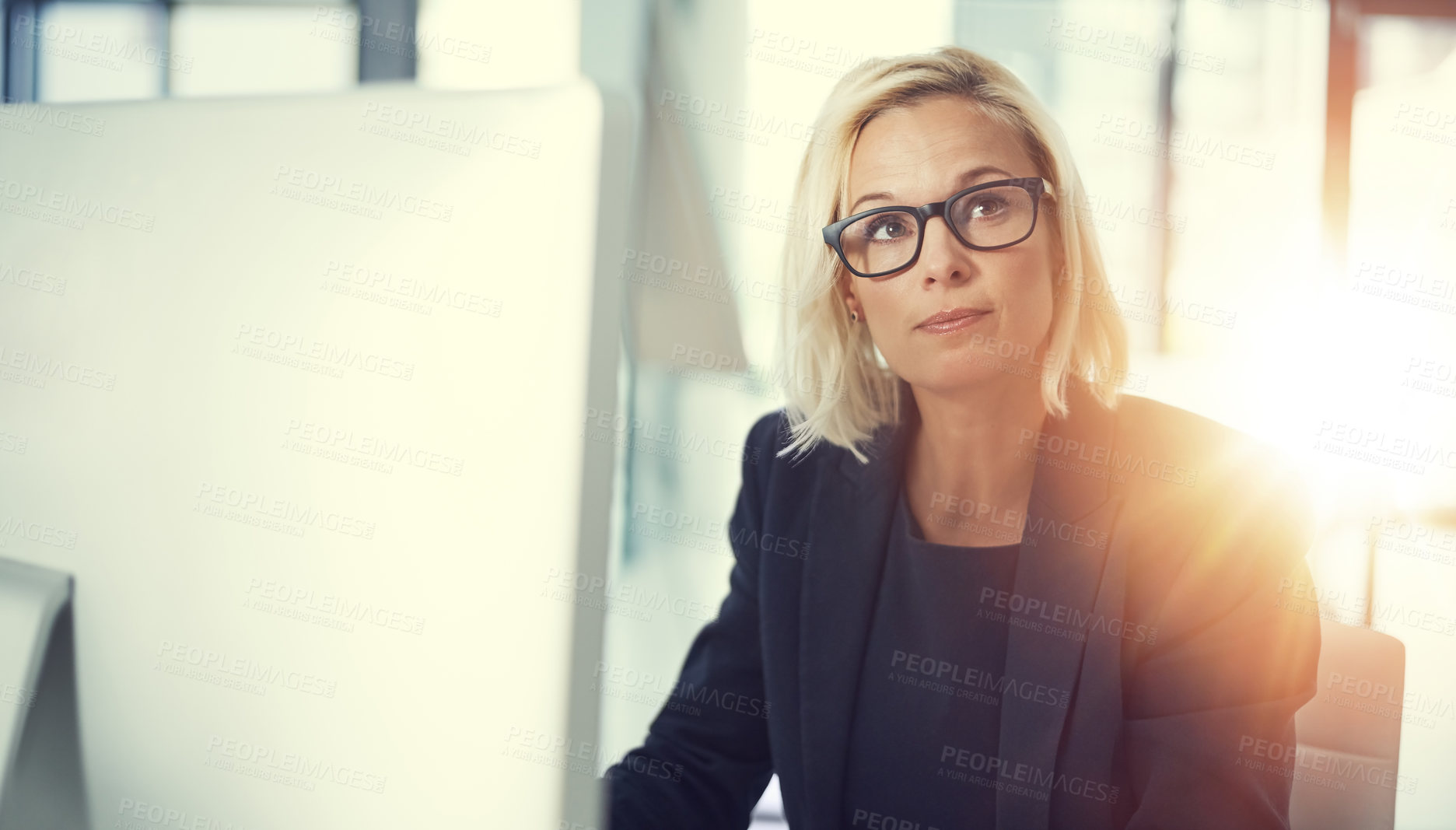 Buy stock photo Shot of a thoughtful businesswoman working at her desk in a modern office