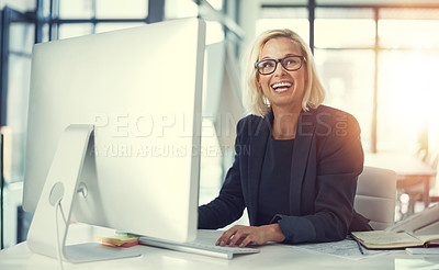 Buy stock photo Shot of a happy businesswoman using a computer at her work desk