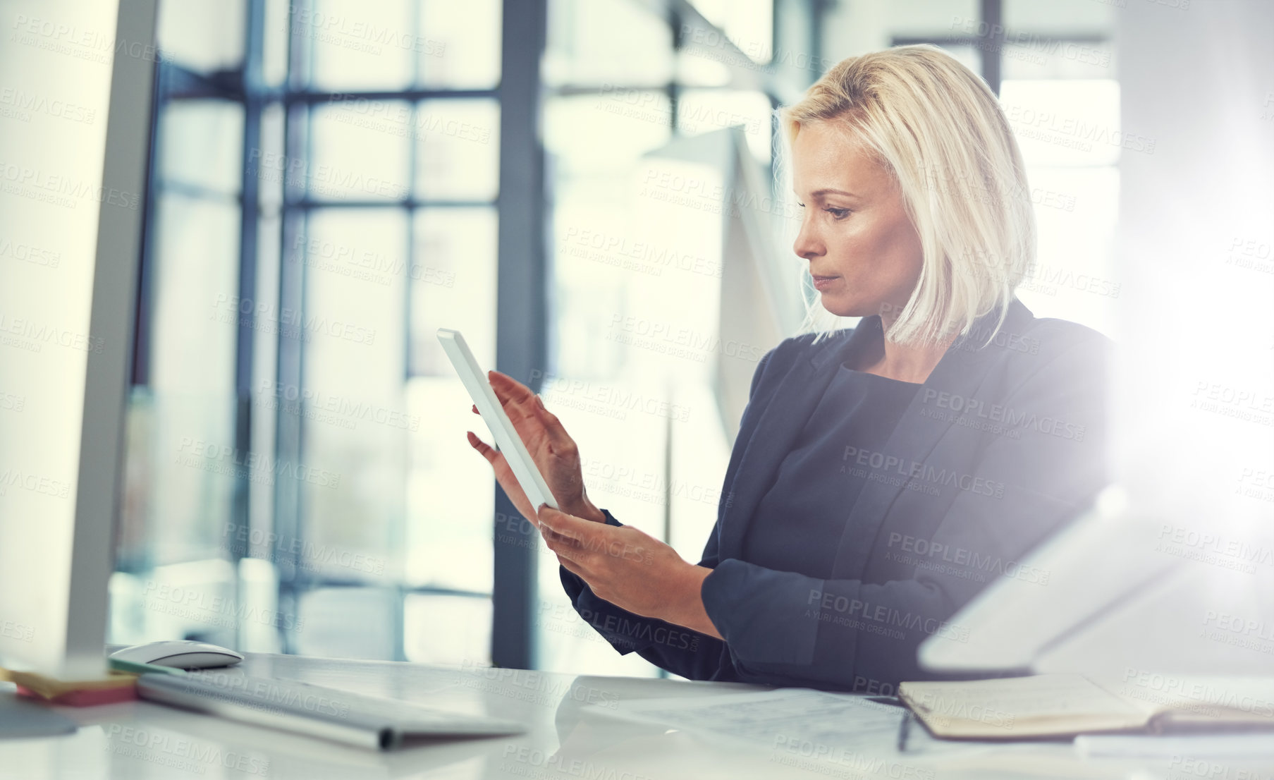 Buy stock photo Shot of a businesswoman using a digital tablet at work