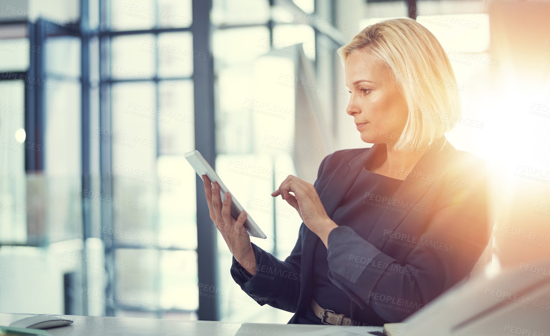 Buy stock photo Shot of a businesswoman using a digital tablet at work