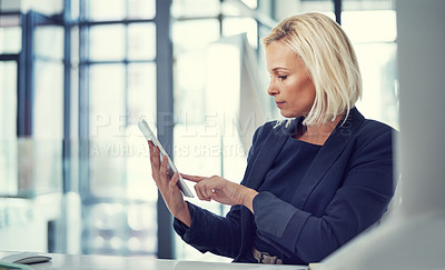 Buy stock photo Shot of a businesswoman using a digital tablet at work