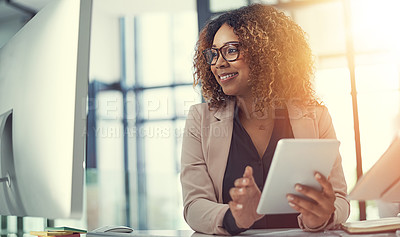 Buy stock photo Shot of a young businesswoman using a digital tablet and computer at work