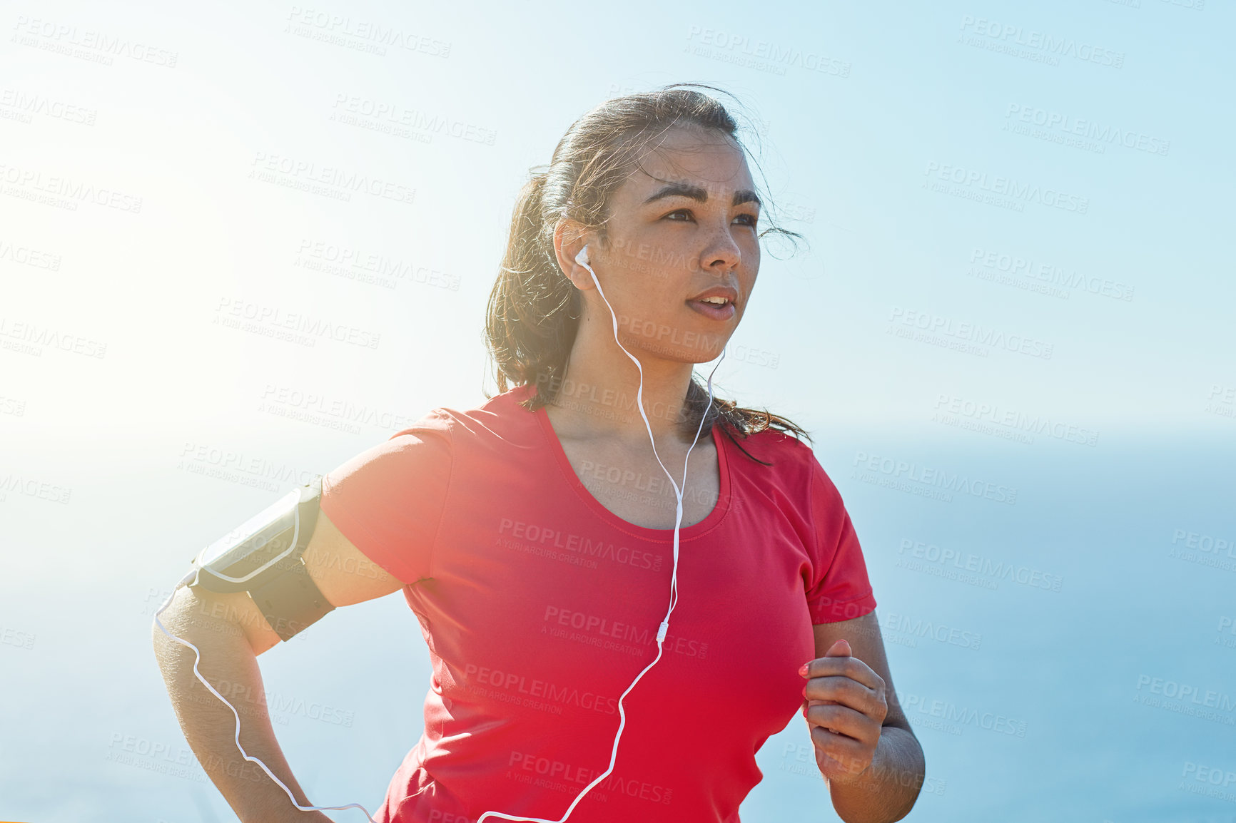 Buy stock photo Female athlete, headphones and running in sunshine with music for race, mission for health or wellness. Woman, runner and outdoor with podcast for sport, fitness or workout with training in Turkey