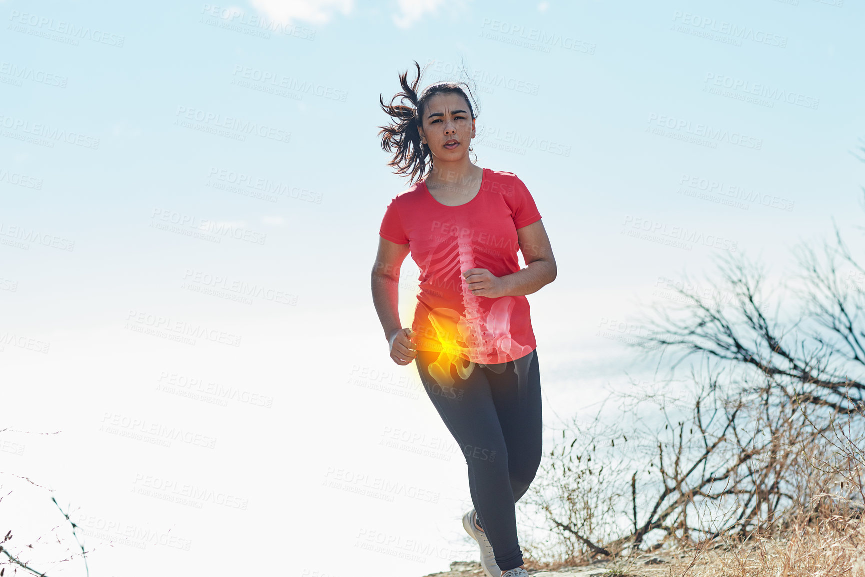Buy stock photo Shot of an attractive young woman running outdoors with her hip injury highlighted