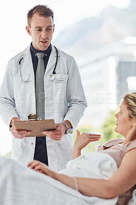 Buy stock photo Cropped shot of a male doctor giving feedback to a patient in a hospital ward