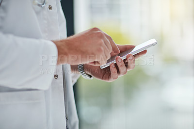Buy stock photo Closeup shot of an unrecognisable doctor texting on his cellphone