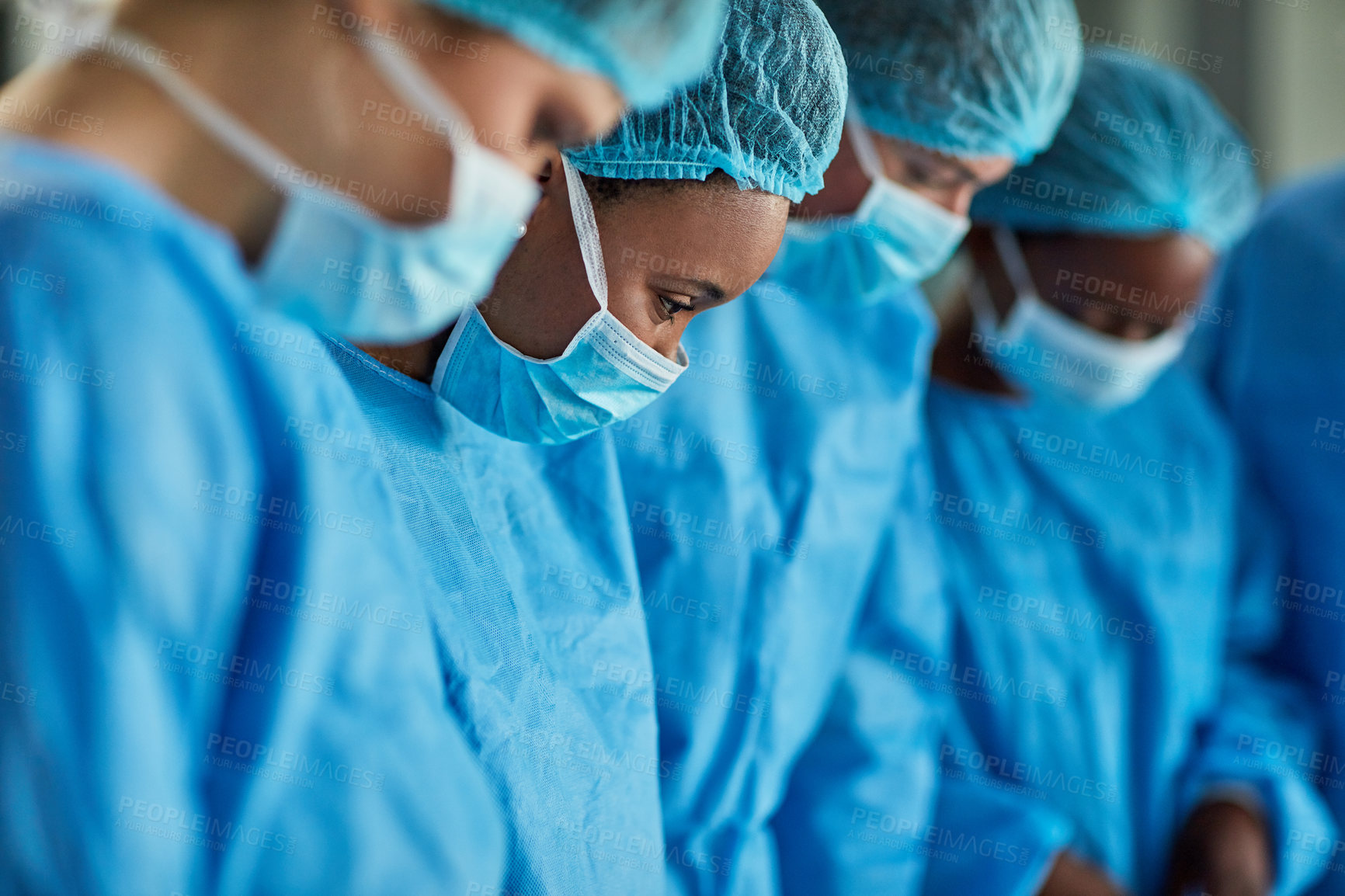 Buy stock photo Cropped shot of a group of surgeons performing a medical procedure in an operating room